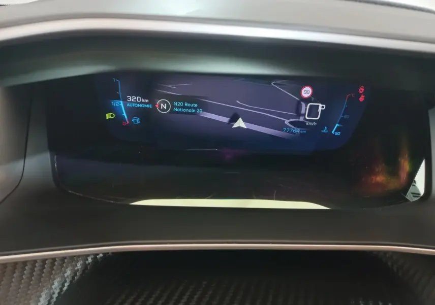 Affichage numérique du tableau de bord de la Peugeot 208 noir, montrant la navigation et les indicateurs de vitesse et autonomie.