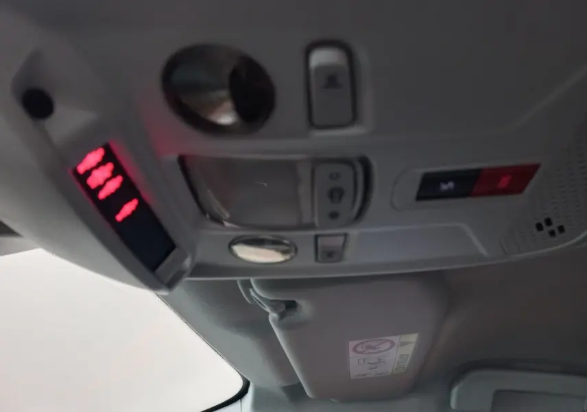 Vue intérieure du plafond avec commandes d'éclairage et panneau d'alerte rouge dans une Peugeot 208 noire 2022.