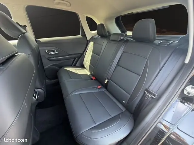 Vue intérieure avant de la MG ZS 1.5 L Hybrid+ 197ch Luxury, tableau de bord moderne et sièges cuir noirs.