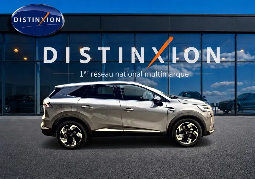 Vue de profil côté gauche d’un Renault Symbioz gris cassiopée avec jantes alu et vitres surteintées devant un showroom Distinxion.