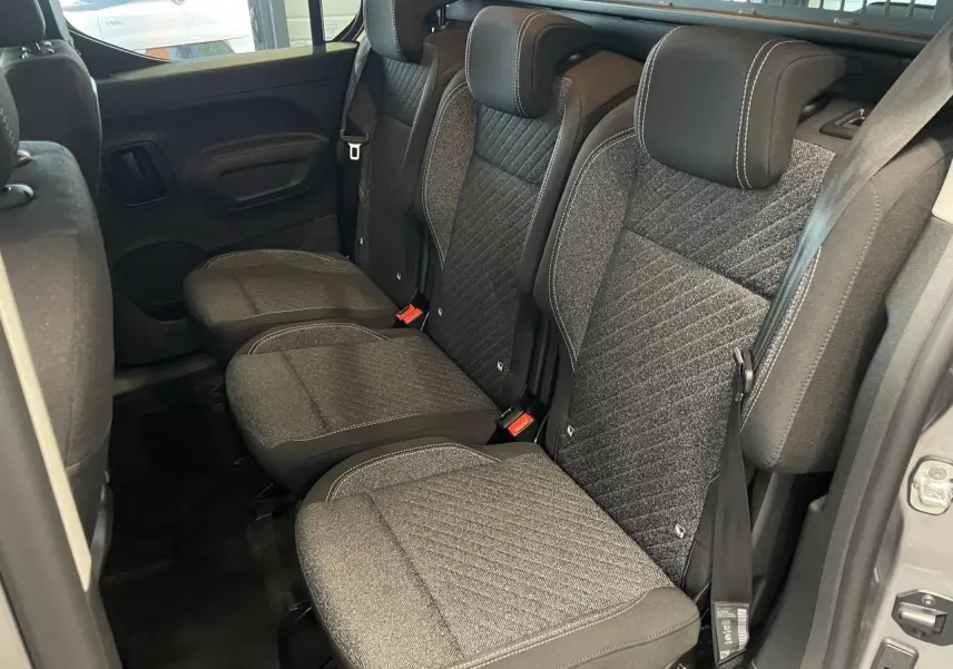 Vue latérale intérieure des sièges arrière en tissu gris du Peugeot Rifter 2026, avec ceintures de sécurité visibles.