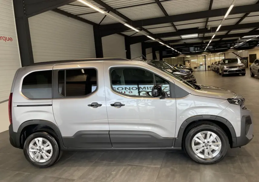 Peugeot Rifter gris Artense vue de profil côté gauche, portes coulissantes et jantes tôles 16 pouces visibles.