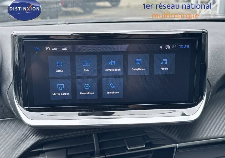 Écran tactile central affichant les options multimédia et climatisation dans l'habitacle d'une Peugeot 2008 noire.