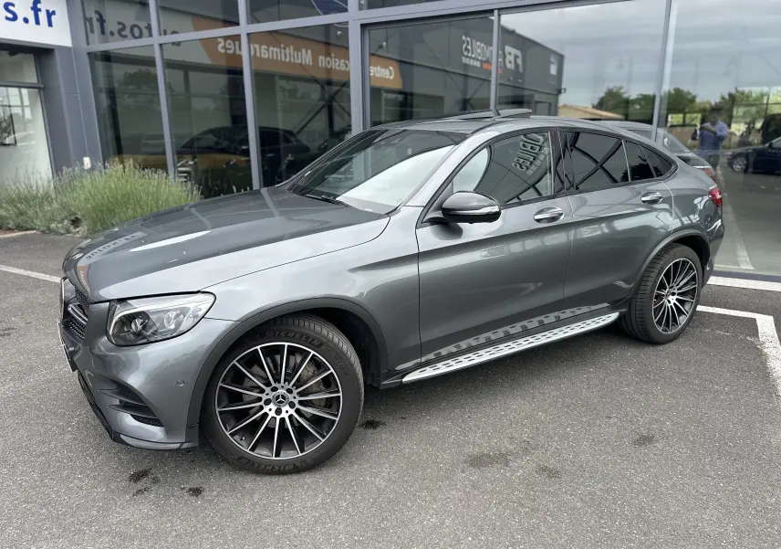 Mercedes GLC Coupé 250 D gris foncé vu de 3/4 avant droit avec jantes alliage et marchepieds métalliques.