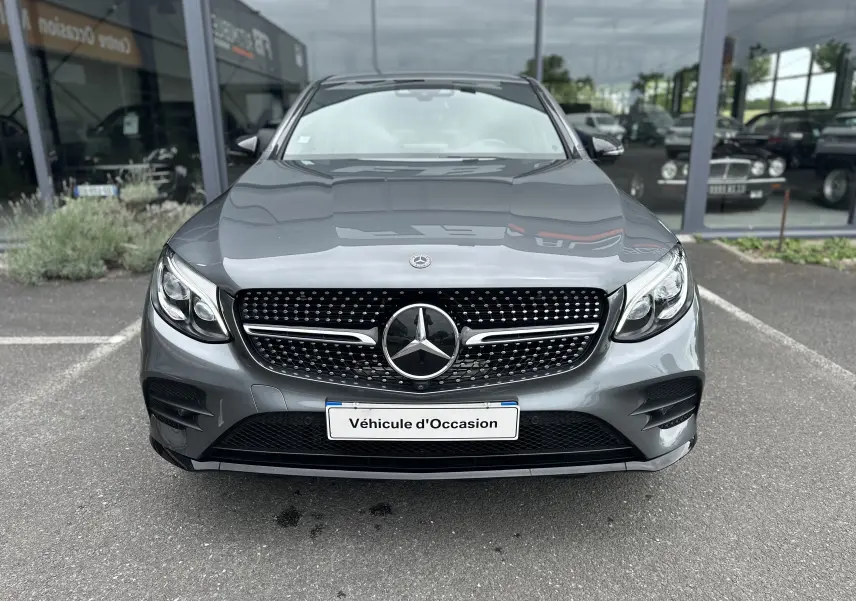 Vue frontale d'un Mercedes GLC Coupé 250 D Fascination gris foncé avec calandre diamant et logo central visible.