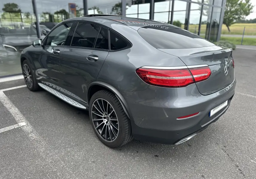 Vue 3/4 arrière droite d'un Mercedes GLC Coupé 250 D Fascination gris foncé avec jantes alliage et vitres teintées.