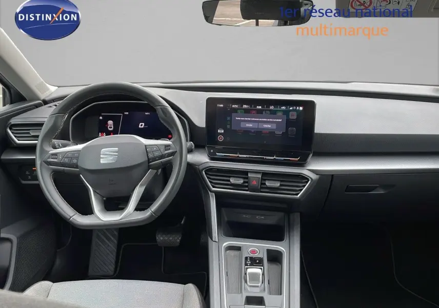 Intérieur moderne gris et noir de la SEAT LEON ST 2023, vue frontale sur le tableau de bord et volant multifonction.