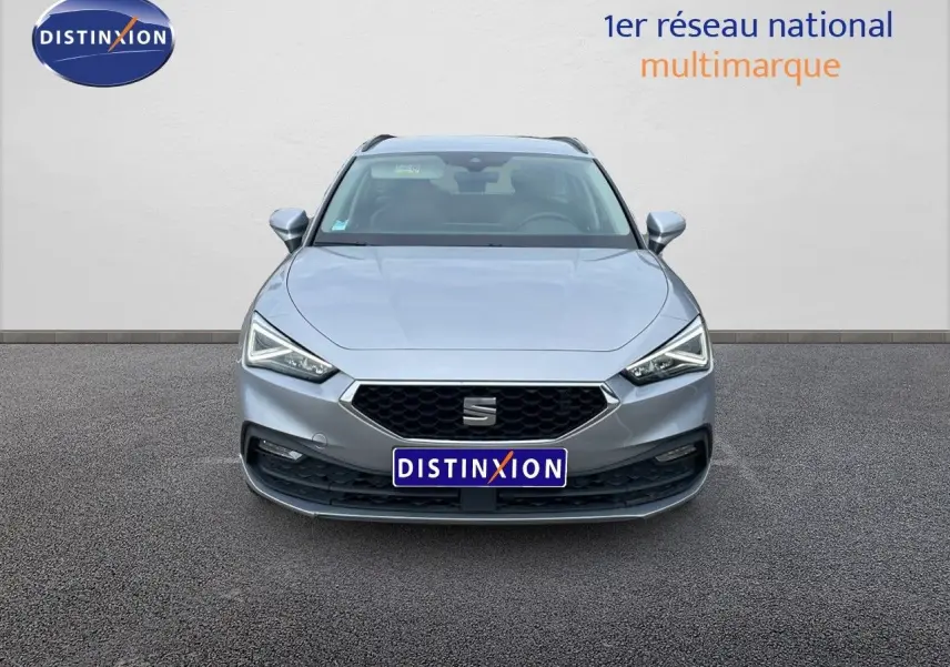 Vue frontale d'une SEAT LEON ST gris urbain 2023 avec calandre hexagonale et phares LED anguleux.