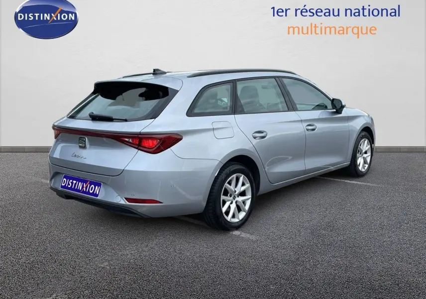 Vue 3/4 arrière droite d'une SEAT LEON ST gris urbain 2023, break compact avec feux arrière LED distinctifs.