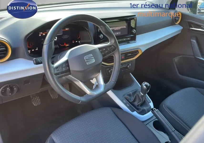 Vue intérieure côté conducteur du tableau de bord et volant du SEAT Arona gris magnétique avec boîte manuelle.