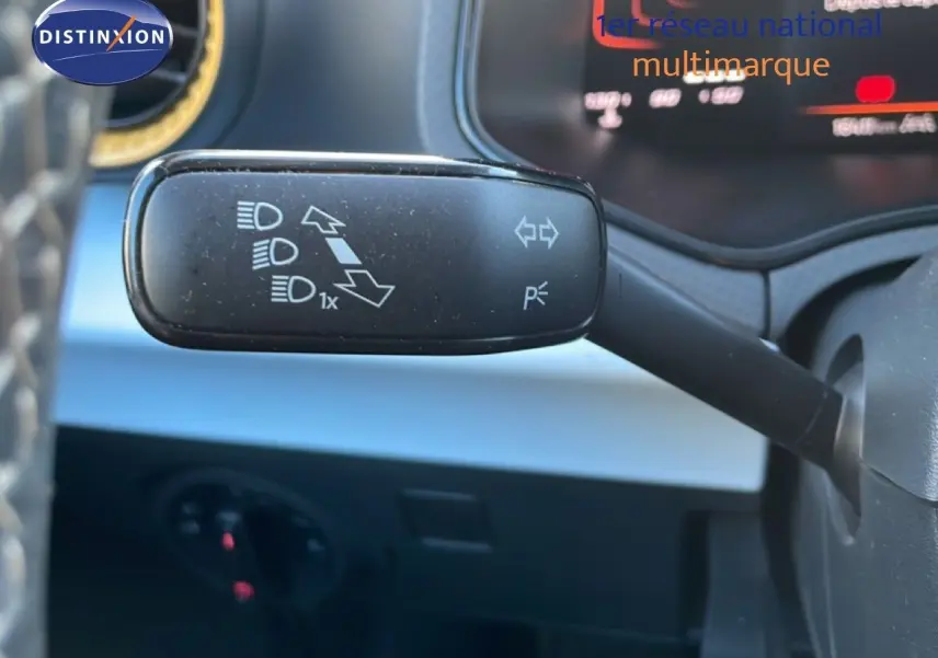 Gros plan sur la commande des clignotants et feux d’un SEAT Arona 2025, intérieur noir avec détails gris.