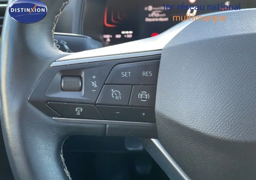 Gros plan sur les commandes au volant côté gauche du SEAT Arona 2025, volant cuir noir avec boutons multifonctions.