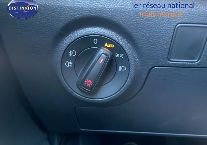 Gros plan sur la molette de réglage des phares dans l'habitacle noir du SEAT Arona 2025.