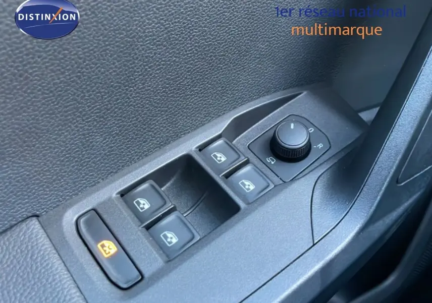 Gros plan sur les commandes des vitres électriques et des rétroviseurs côté conducteur d'une SEAT Arona gris magnétique.