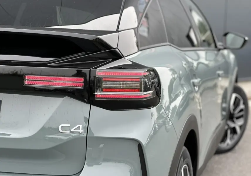 Vue 3/4 arrière droite d'une Citroën C4 Manhattan Green avec toit noir et feux arrière LED distinctifs.