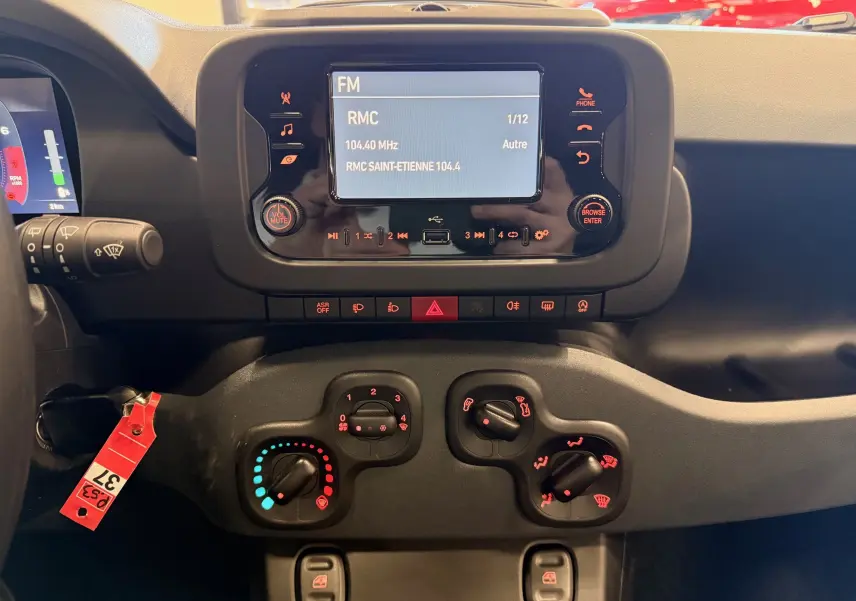 Vue rapprochée du tableau de bord de la Fiat Panda 1.0 Hybrid 2025 avec écran central tactile et commandes de climatisation.