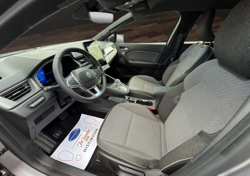 Vue intérieure côté conducteur de la Renault SYMBIOZ gris clair, avec tableau de bord digital et sièges tissu gris.