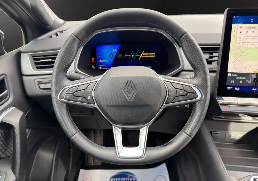 Vue rapprochée du volant noir perforé et du tableau de bord numérique du Renault Symbioz 2025 hybride.
