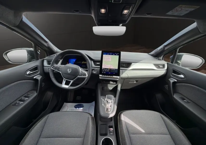 Vue intérieure avant du Renault SYMBIOZ gris clair, avec tableau de bord digital et écran tactile central vertical.