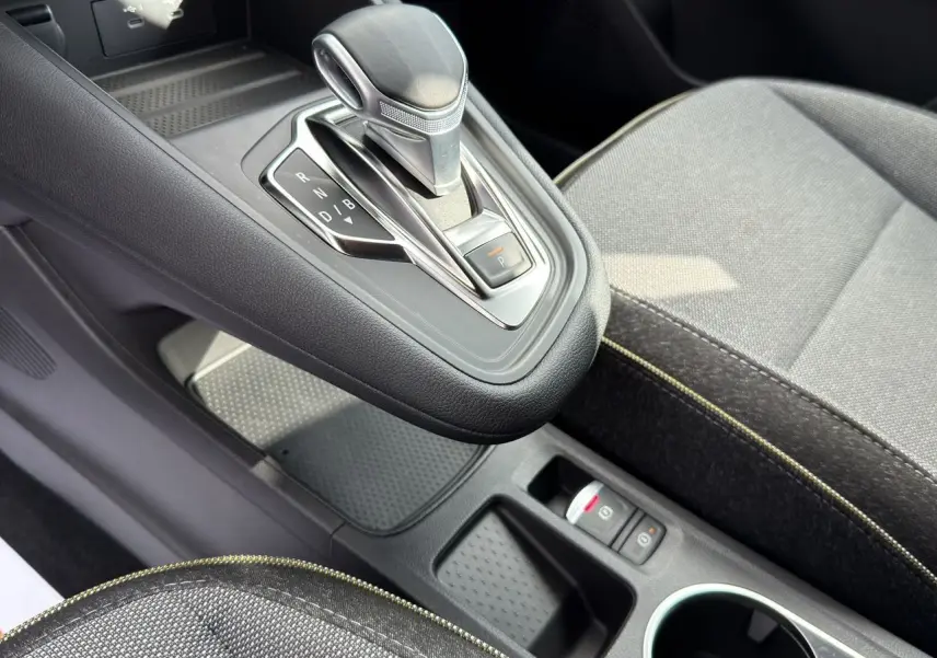 Gros plan sur la console centrale et levier de vitesse automatique du Renault SYMBIOZ gris clair, avec sièges tissu gris.