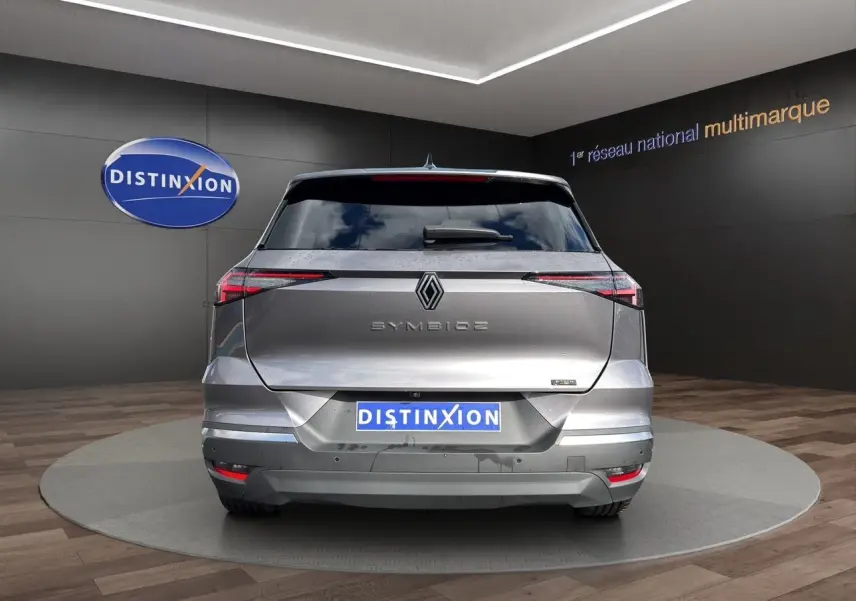 Vue arrière d'une Renault Symbioz gris clair 2025 avec feux LED fins et logo central distinctif.