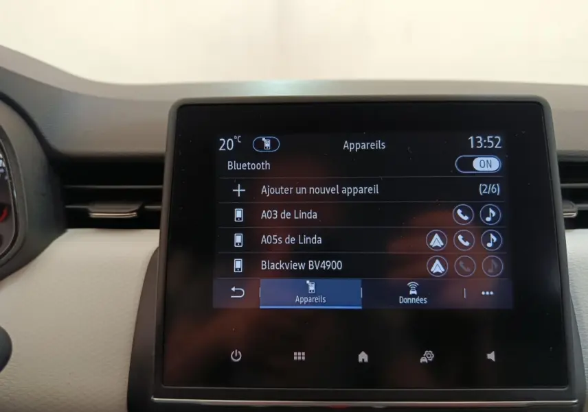 Écran tactile central de la Renault Clio blanc montrant la connexion Bluetooth et la liste des appareils associés.