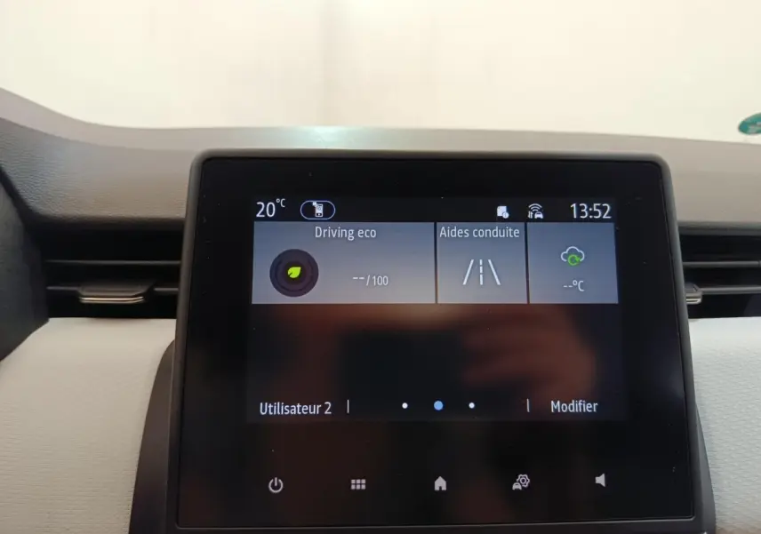 Écran tactile central de la Renault Clio blanc 2023 affichant les aides à la conduite et la température intérieure.