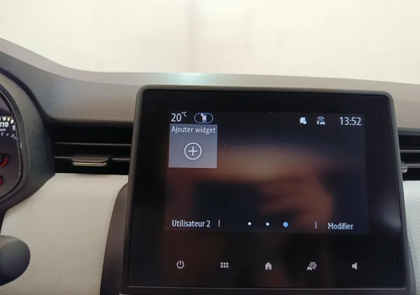 Écran tactile central de la Renault Clio blanc 2023 affichant le menu principal avec options utilisateur.