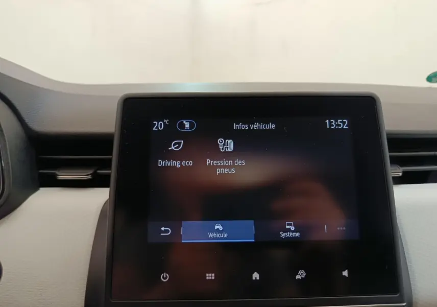 Écran tactile central de la Renault Clio blanc, affichant les infos véhicule en intérieur, vue frontale rapprochée.