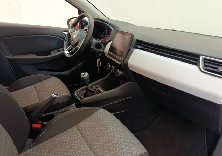 Vue intérieure côté conducteur de la Renault Clio Evolution TCe 100 GPL 2023, montrant tableau de bord et sièges gris.