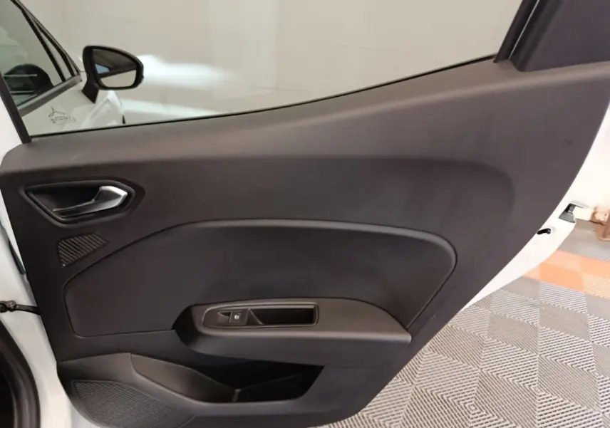 Vue rapprochée de la porte arrière droite noire intérieure de la Renault Clio blanche Evolution TCe 100 GPL 2023.