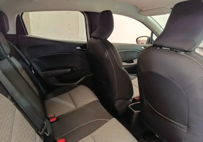 Vue intérieure côté gauche montrant la banquette arrière et les sièges avant noirs de la Renault Clio blanche.