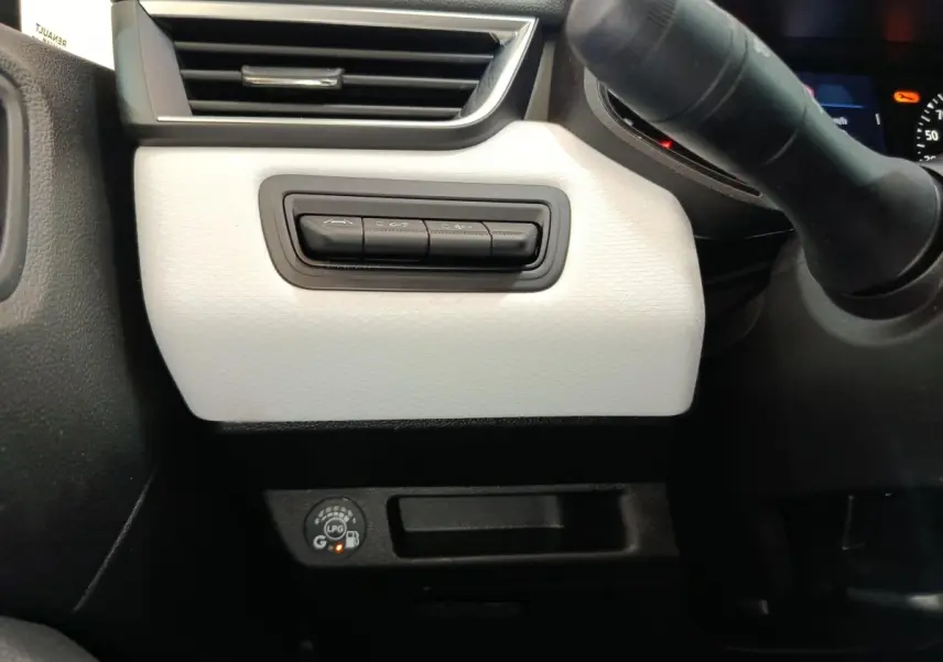 Détail du tableau de bord blanc côté gauche avec commandes et indicateur GPL allumé sur Renault Clio 2023.