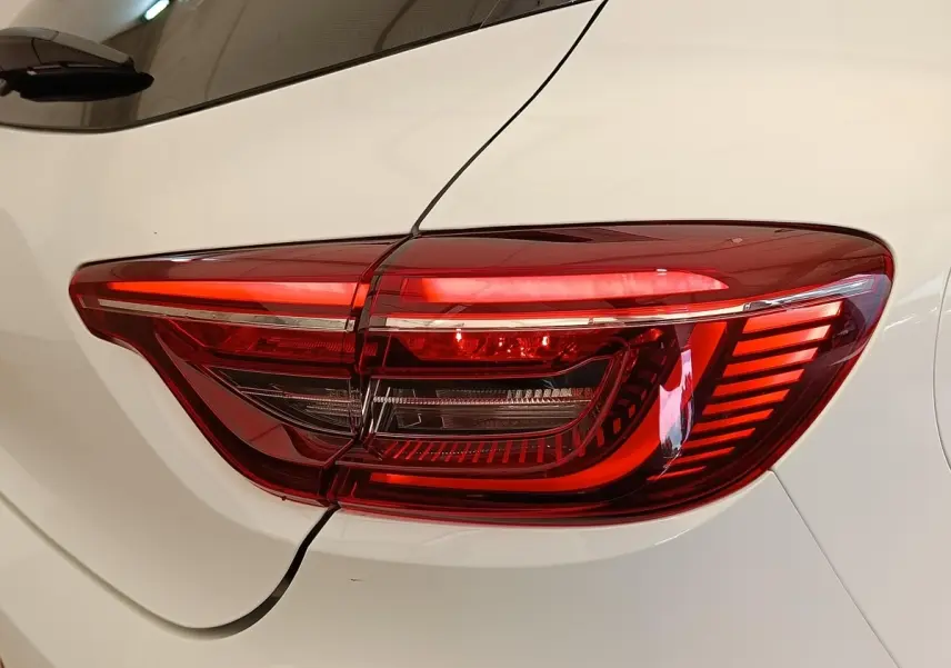 Gros plan sur le feu arrière droit rouge de la Renault Clio blanche Evolution TCe 100 GPL 2023.