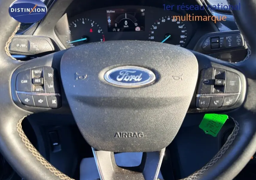 Vue rapprochée du volant noir de la Ford Puma 2023 avec commandes intégrées et tableau de bord digital.