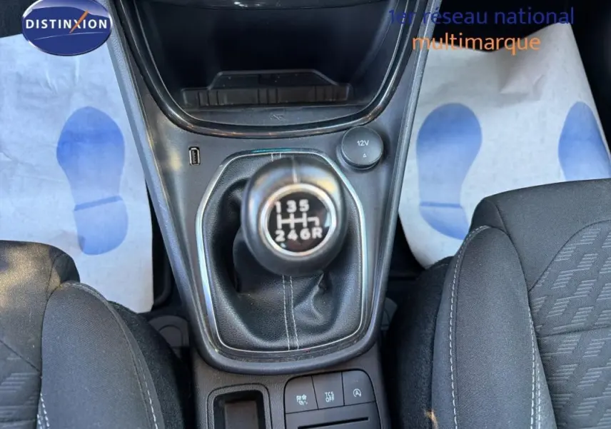 Vue rapprochée de la boîte manuelle noire et des sièges sport en tissu gris foncé dans un Ford Puma noir 2023.