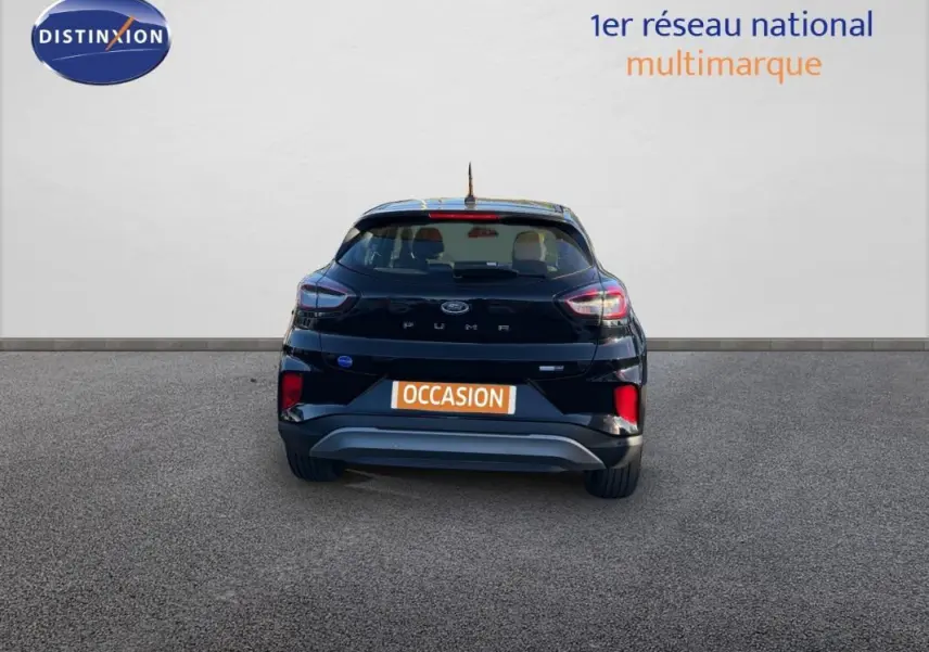 Vue arrière d'un Ford Puma noir 2023 avec feux allumés sur fond neutre, plaque "OCCASION" visible.