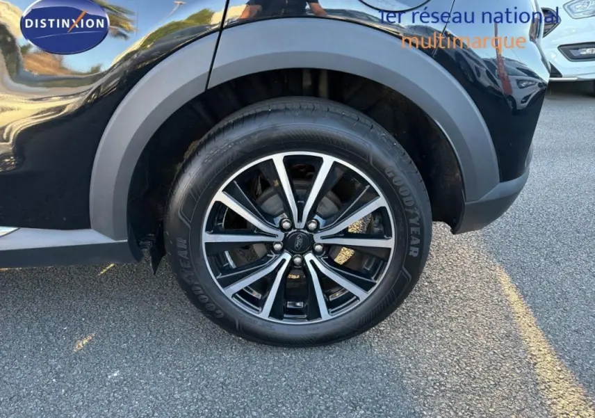 Gros plan sur la roue arrière droite noire du Ford Puma 2023 avec jante 17 pouces bicolore et logo Ford visible.