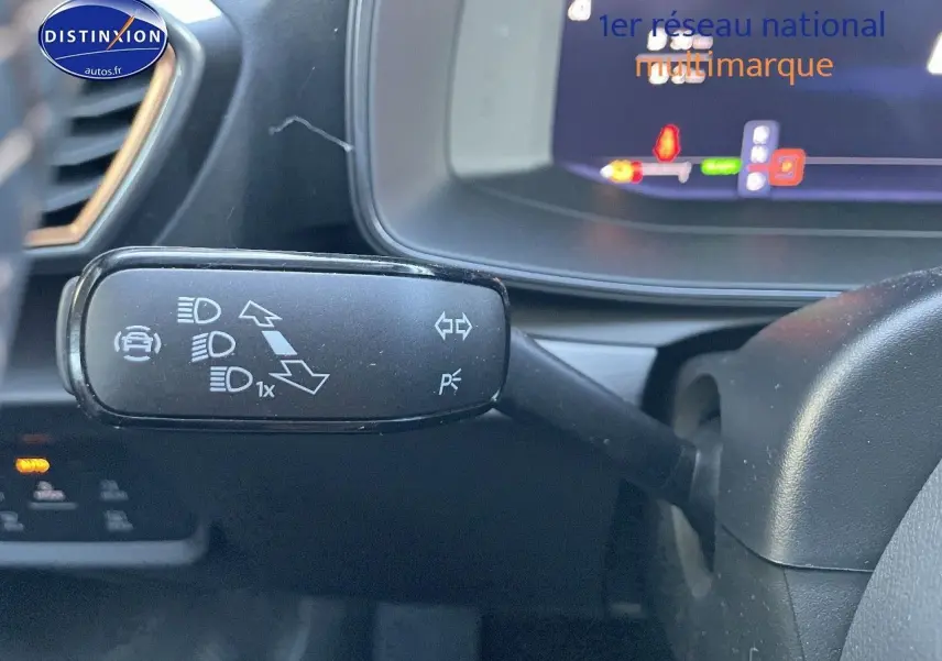 Gros plan sur la commande de clignotant à gauche du volant dans l’habitacle sombre du CUPRA Formentor gris magnétique 2024.