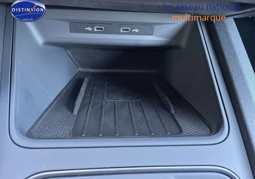 Gros plan sur la console centrale du CUPRA Formentor gris magnétique, montrant la zone de recharge sans fil et ports USB.