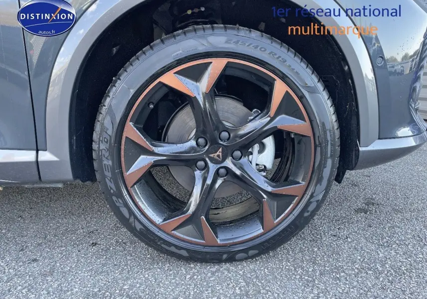 Gros plan sur la roue avant gauche d’un CUPRA Formentor gris magnétique avec jante noire et cuivre en étoile.