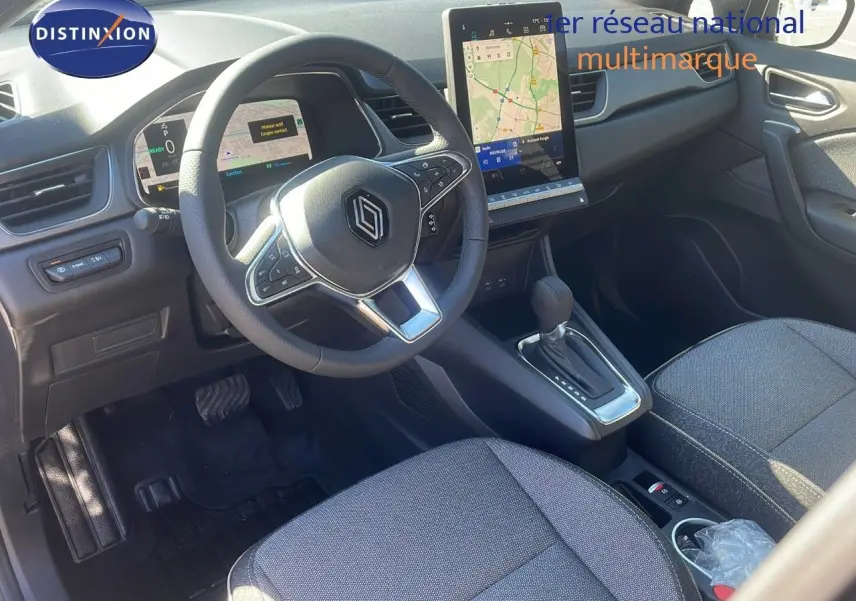 Intérieur Renault Captur E-Tech hybride 2025 vu côté conducteur, volant multifonction et écran tactile vertical.
