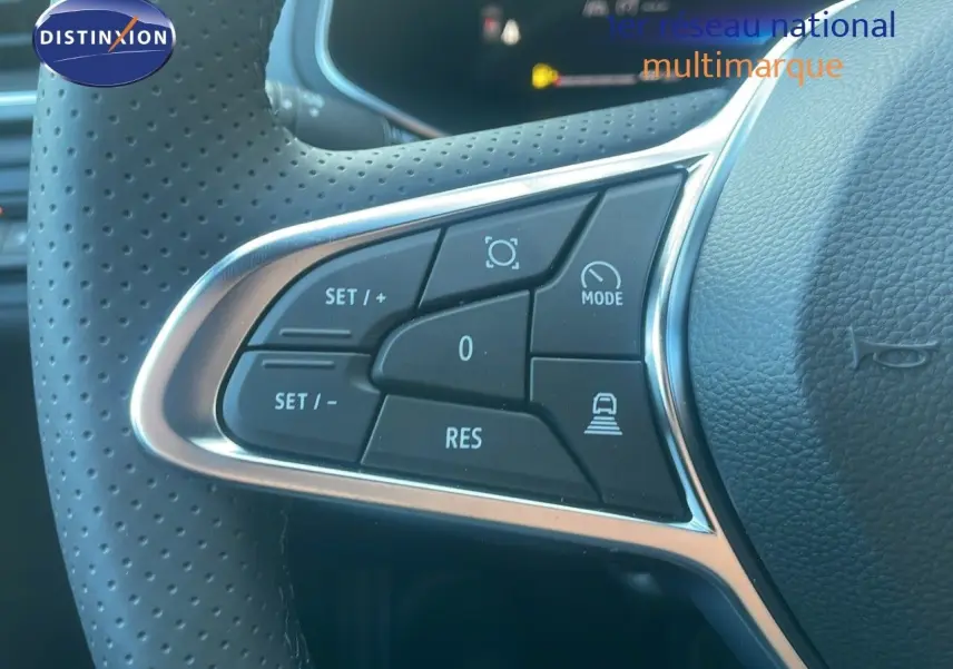 Gros plan sur les commandes de régulateur de vitesse au volant perforé du Renault Captur E-Tech hybride noir étoile métal 2025.