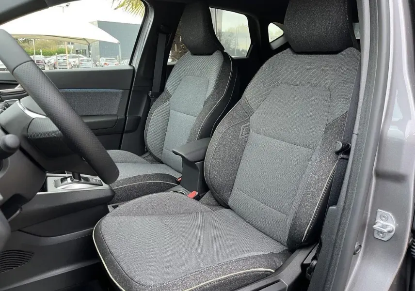Vue intérieure côté gauche montrant les sièges avant gris du Renault Captur 2025 en version hybride full hybrid.
