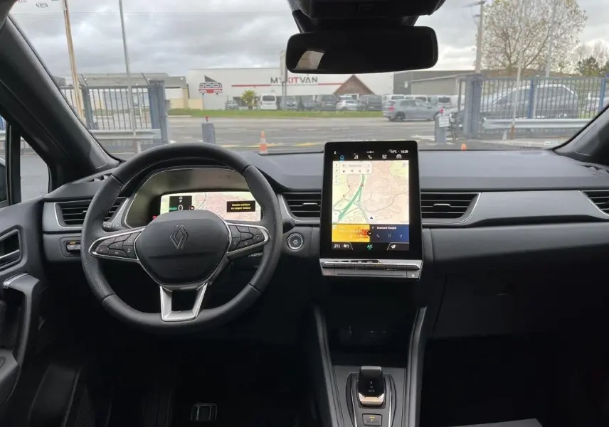 Vue intérieure frontale du tableau de bord du Renault Captur gris Cassiopée 2025 avec écran tactile vertical et volant multifonction.