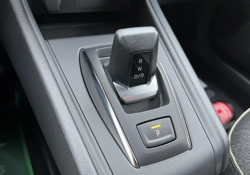 Gros plan sur le levier de vitesses automatique noir et gris du Renault Captur 1.8 E-TECH hybride, avec bouton de parking éclairé.