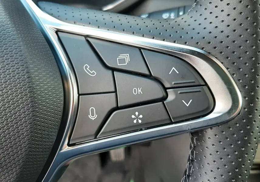 Gros plan sur les commandes multifonctions côté droit du volant perforé du Renault Captur gris Cassiopée 2025.