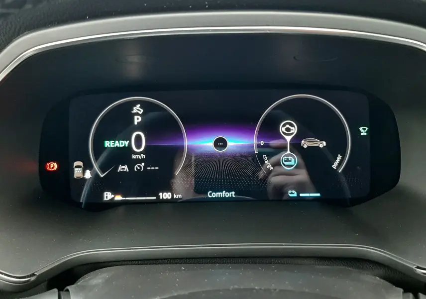 Gros plan sur le tableau de bord numérique du Renault Captur hybride 2025, affichant la vitesse à zéro et le mode confort.