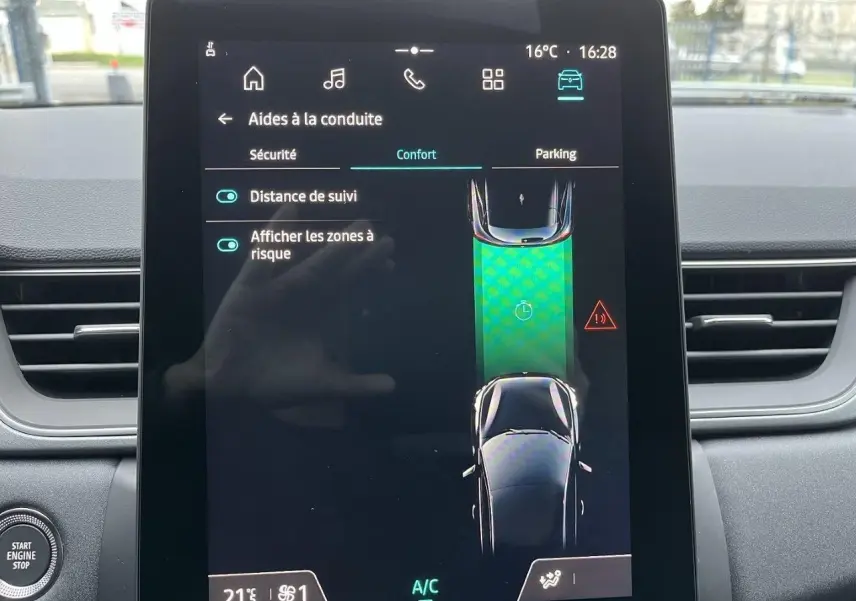 Écran tactile central du Renault Captur 2025 montrant les aides à la conduite, avec tableau de bord gris en arrière-plan.