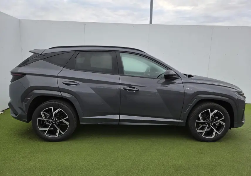 Profil droit du Hyundai Tucson 2025 gris métallisé avec jantes alliage 19'' N Line et détails noirs contrastés.